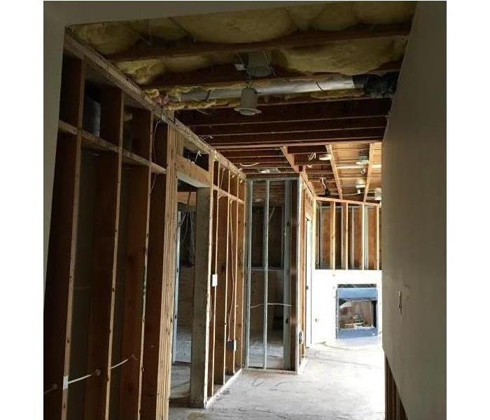 demolition reveals the interior framing and concrete pad, dried
