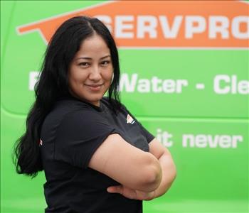 female employee wearing a black SERVPRO shirt standing next to a SERVPRO truck