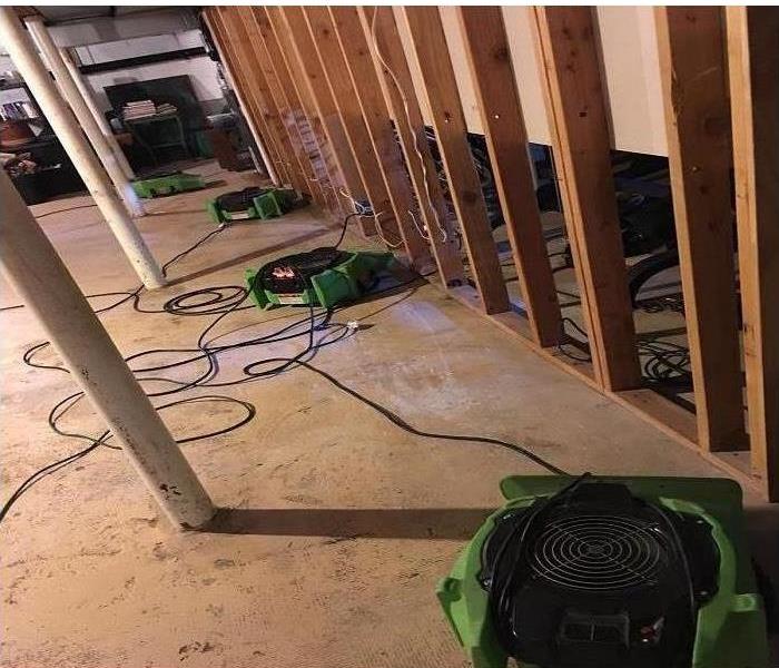 bare concrete floor, studs, and air movers