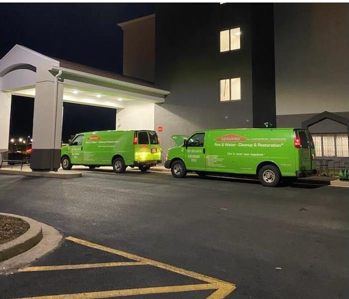 Two SERVPRO vans in front of a hotel