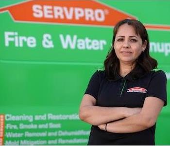 Young woman with dark, shoulder length hair and dark eyes wearing a green SERVPRO logo golf shirt by a green SERVPRO truck